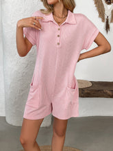 Woman walking in blush pink romper with sneakers and crossbody bag.