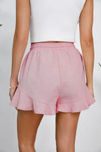Blush pink shorts from behind, revealing flattering high-rise and breezy fit.