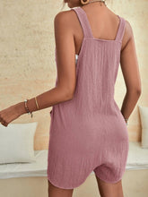 Back view of blush pink romper featuring soft drape and adjustable tie details.