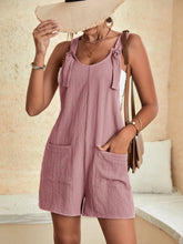 Blush pink romper paired with a crossbody bag and flats for a romantic day-date look.