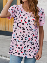 Model styled in blush pink leopard round neck tee with soft short sleeves, paired with white skinny jeans and gold hoops.
