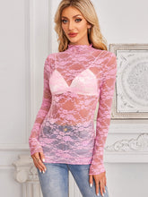 Side profile of model in a blush pink Mock Neck Long Sleeve Lace Sheer Top, paired with tailored pants for a chic, sophisticated look.