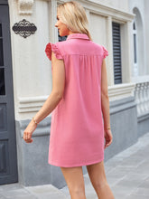 Model showcasing  a back view of the blush pink color Ruffled Button Up Cap Sleeve Denim Dress walking through the park.