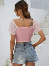 Back view of Glowflutter Crop Top showing soft fabric and flutter sleeve flow, worn by model in blush pink.