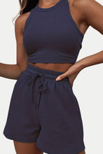 Close-up photo of a model showcasing the dark blue Boundary Babe Round Neck Top and Drawstring Shorts Set paired with a gold bracelet for relaxed outdoor lunch.