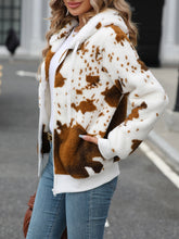a model showcasing the side of a brown Western Patch design Fuzzy Drawstring Zip Hooded Jacket paired with jeans, handbag, and jewelry. 
