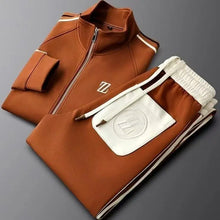 Neatly folded Varnox LuxeTrak jacket and pants set in Brown.