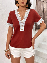 Side view of model wearing a burgundy Lace Detail V-Neck Short Sleeve T-Shirt, highlighting the wavy lace sleeve trim and decorative buttons at the neckline.