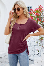 Model wearing a burgundy ruched square neck T-shirt with short sleeves, paired with classic denim.