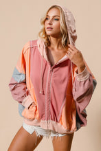 Front view of model wearing a burnt coral Full Size Color Block Zip Up Hoodie, featuring bold contrasting panels, front zipper closure, and a relaxed hooded silhouette.