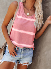Model wearing a burnt coral tie-dye tank, smiling outdoors on a sunny day, styled with denim shorts and sunglasses.