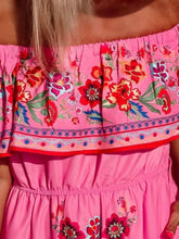 Close-up of vibrant floral print and ruffled off-shoulder on fuchsia pink Isadorae Dress.