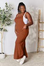 Side profile of Ochre Cyrella Muse Overalls, showcasing wide straps and pocket details.