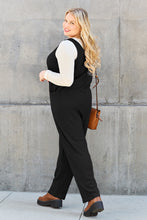 Back view of Black Caeloura Jumpsuit against mansion setting.