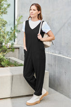 Gold jewelry adding luxe shine to Black Caeloura Jumpsuit.