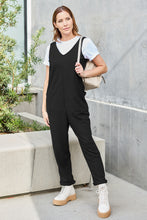 Walking through garden in Black Caeloura Jumpsuit with white platform boots.
