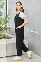 Side profile of Black Caeloura Jumpsuit showing sleek cut and pockets.