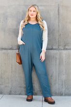 Model in Sky Blue Caeloura lounging against brick wall, radiating relaxed resort elegance.
