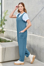 Side profile of Sky Blue Caeloura Jumpsuit, highlighting pockets and flowing straight-leg fit.