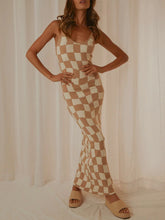 Front view of a model styled in Camel Luxnometry Maxi Sweater Dress standing in a mansion corridor with bold gold accessories.