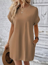 Model in Camel Rahluna Mini Tee Dress styled with gold jewelry and wedge sandals for a lunch date.