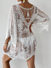 Back view of Celévra Lace Round Neck Cover-Up Dress in black featuring plunging round neck back and zig zag hem