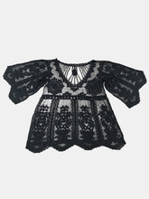 Flat lay of Celévra Lace Round Neck Cover-Up Dress in black showing floral lace and zig zag hemline