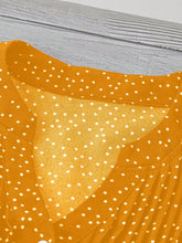 Close-up of neckline slit and buttons on gold EverDot Flutter Top.