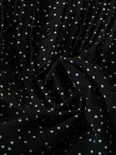 Close-up of black EverDot Flutter Top's premium fabric texture and button detailing.