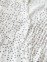 Close-up of neckline slit and buttons on white EverDot Flutter Top.