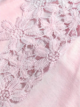 Close-up of the lace floral detailing on the shoulder cutouts.