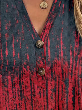 Close-up of half button-up and button  detail on burgundy  Printed Short Sleeve Blouse.