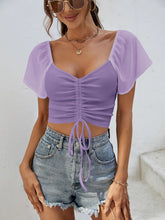 Close-up of adjustable front-center drawstring on Glowflutter Crop Top in pink purple, highlighting stretch fabric and ruching.