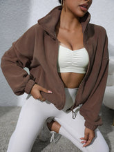 coffee brown turtleneck zip up jacket floor stretching pose