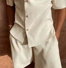 Close-up of sleeve, buttons, and shorts detail on creamy white Cordavé set