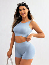 Model wearing Light Blue CoreLyte PulseActive top & shorts, front view showing round neck and high-rise fit.