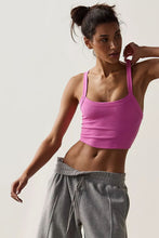 Woman in pink Crestline Wave Active Tank stretching in park.