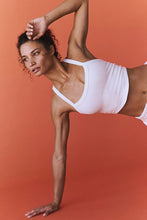 Woman wearing white Crestline Wave Active Tank in a yoga asanas.
