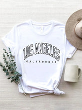 CaliVista Tee in white paired with straw hat in flat lay, styled for casual summer outfit inspiration.
