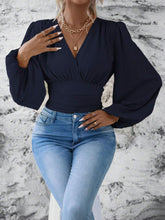Model styled in dark blue Balloonique™ Blouse with accessories for a complete look.