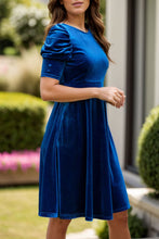 Side profile of Seylurette Velvet Dress in dark blue highlighting puff sleeve and smooth velvet drape.