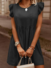 Model in dark gray Sylvenza Denim Dress styled with tan and gold handbag and accessories standing on urban city street.