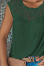 Close-up detail of lace patchwork neckline and semi-sheer fabric in dark green.