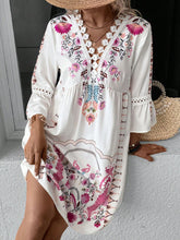 Woman seated at a resort window sill in Deep Rose Qelorian Lace Mini Dress with bronze jewelry and wooden handbag.