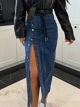 Zoomed in side view of Denavelle Row Skirt medium blue highlighting adjustable button slit and seam detail