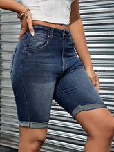 Side zoom-in on dark blue high wiast jean shorts showing slim fit and washed design.