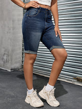 Styled side view of denim shorts with white top and sneakers.