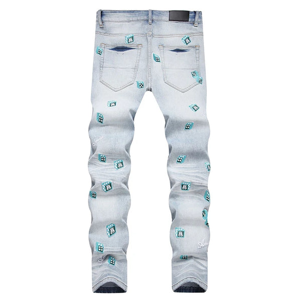 Back view of light blue skinny-leg denim jeans with light blue dice, letter embroideries, and washed finish.