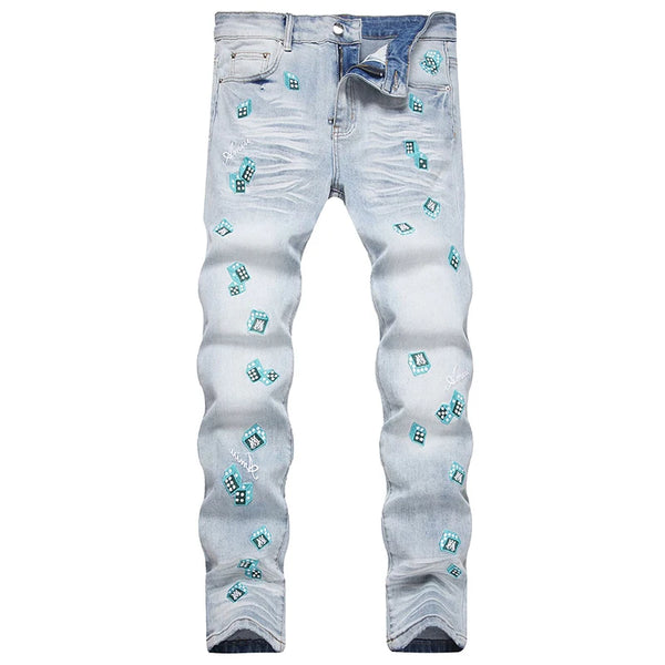 Front view of light blue skinny-leg denim jeans with light blue dice, letter embroideries, and washed finish.