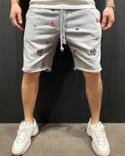 Front view of gray embroidered men’s Bermuda shorts with colorful stitching.